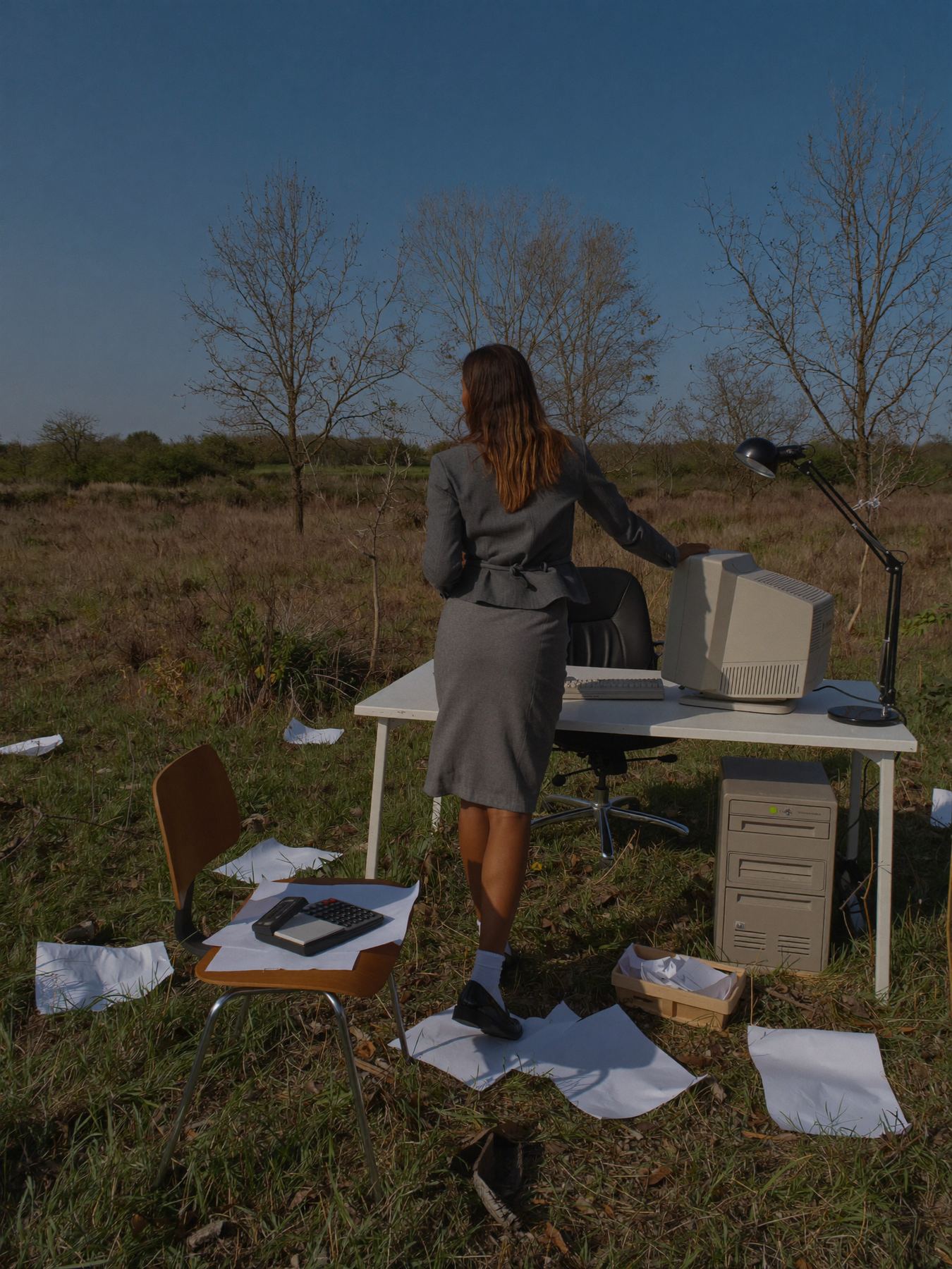 Out of office — woman working at an outdoor desk with vintage computer, limitls brand imagery